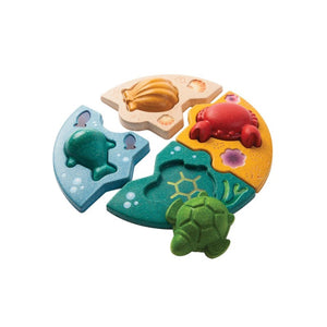 marine puzzle by plan toys includes; includes a shell, crab, turtle and whale with interlocking background pieces to match the environment