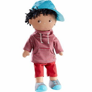haba 12 inch soft african american doll wearing a striped sweatshirt, red pants and blue and grey  shoes