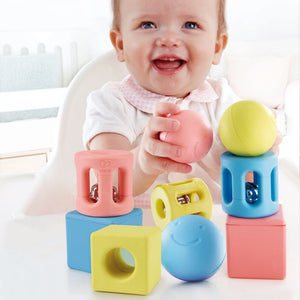 hape geometric trio rattle set contains 9 pieces in blue, yellow, and pink