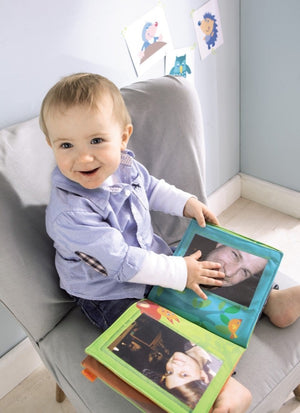 toddler enjoying the photos in the First Photo Album Friends of the Enchanted Forest by Haba