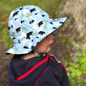 Cotton floppy hat by jan and jul in bear print, black bears, pine trees and mountains on a pastel pine tree background