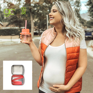pregnant woman enjoying a beverage with her go sili reusable 8" straw that comes with a compact tin