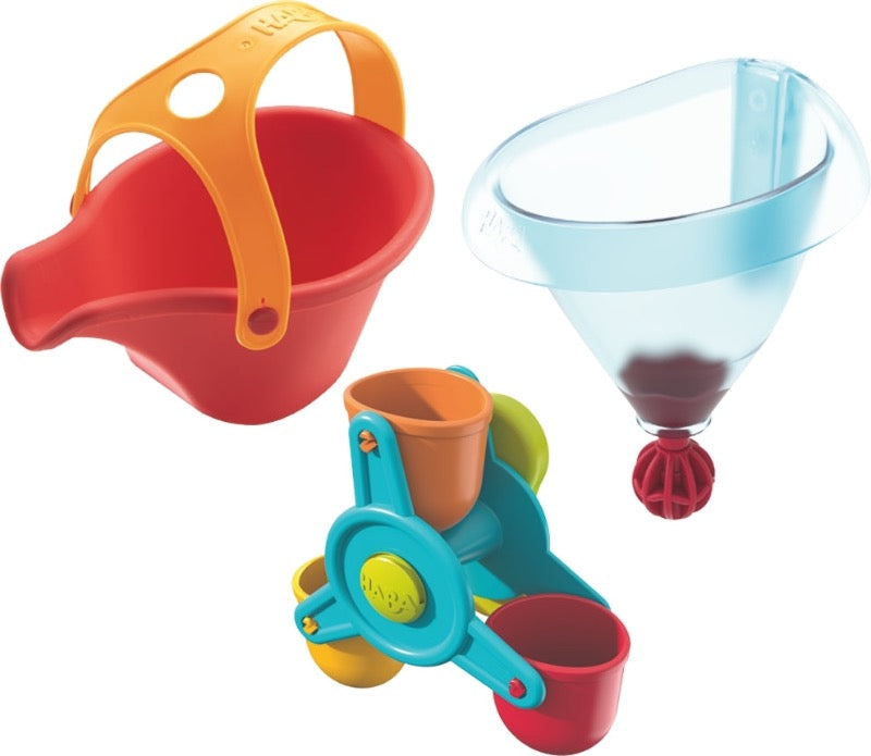 Packaging for the Haba Bathing Bliss Water Wonders bath toy, red watering can, water wheel with 3 colorful buckets, and a funnel